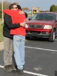 man in red jacket hugging man in black jacket in parking lot front of red Ford Explorer