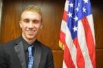 American flag and male BHC student in a black suit