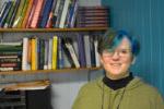 smiling instructor in office with shelves filled with math books behind her