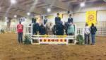 6 students standing in dirt next to 4 people sitting on horses