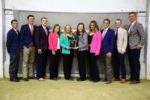 10 people lined up with plaque & smiling at camera